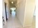 Bright hallway featuring neutral tile flooring leading to the living area with sliding glass doors at 1726 Augustine Dr, The Villages, FL 32159