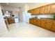 Spacious kitchen featuring tile floors, wood cabinets, and access to other rooms at 1726 Augustine Dr, The Villages, FL 32159