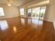 Spacious living room with hardwood floors and large windows, complemented by a ceiling fan at 1726 Augustine Dr, The Villages, FL 32159