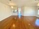 Large living room with hardwood floors, chandelier, and a view into the kitchen and hallway at 1726 Augustine Dr, The Villages, FL 32159