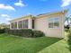 Exterior view of home showcasing a lush lawn, manicured bushes, and a sunroom at 17660 Se 81St Timberwood Ter, The Villages, FL 32162