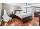 Main bedroom featuring a ceiling fan, white bedding, wooden furniture, and shuttered windows at 17660 Se 81St Timberwood Ter, The Villages, FL 32162