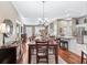 Open concept dining room with wood floors, stylish chandelier, seamlessly connected to the kitchen and living spaces at 17660 Se 81St Timberwood Ter, The Villages, FL 32162