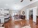 Elegant dining area with hardwood floors, a modern chandelier, and an open view of the kitchen at 17660 Se 81St Timberwood Ter, The Villages, FL 32162