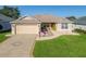 Charming single-story home featuring a two-car garage, decorative driveway, and nicely landscaped front yard at 17660 Se 81St Timberwood Ter, The Villages, FL 32162