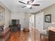 Cozy living room with wood floors, ceiling fan, TV and doorway leading to another room at 17660 Se 81St Timberwood Ter, The Villages, FL 32162