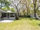 Expansive backyard featuring a screened porch, lush lawn, mature trees, and a wooden fence with decorative flower boxes at 18319 Dells Cove Rd, Groveland, FL 34736