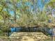 Dock on backyard canal, surrounded by mature trees, and lush landscaping at 18319 Dells Cove Rd, Groveland, FL 34736