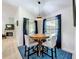 Dining area features a modern round table, chair seating, pendant lighting, and natural light from the windows at 18319 Dells Cove Rd, Groveland, FL 34736