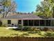 Rear exterior view features a screened patio and manicured gardens of colorful flowers and lush greenery at 18319 Dells Cove Rd, Groveland, FL 34736