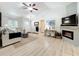 Bright living room with vaulted ceilings, a ceiling fan, and an electric fireplace at 18319 Dells Cove Rd, Groveland, FL 34736