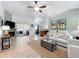 Bright living room featuring neutral colors, a ceiling fan, and a view of the sunroom at 18319 Dells Cove Rd, Groveland, FL 34736