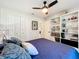 Large main bedroom with white storage shelves, bright white ceiling fan, and a closet at 18319 Dells Cove Rd, Groveland, FL 34736