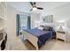 Bright main bedroom features modern décor, white furniture, a ceiling fan and plenty of natural light at 18319 Dells Cove Rd, Groveland, FL 34736