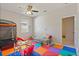 Spacious playroom featuring a soft gray couch, window with blinds, and a colorful floor mat for playing at 1851 Soaring Heights Cir, Orlando, FL 32837