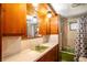 Classic bathroom with wooden cabinets, a vintage green sink, and a shower-tub combination at 19050 Nfs-573, Altoona, FL 32702