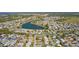 Expansive aerial view of a residential community with lush landscaping and a serene lake at 2008 Cipriano Pl, The Villages, FL 32159