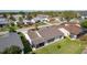 Aerial view of home's backyard with screened in patio overlooking manicured lawn and landscaping at 2008 Cipriano Pl, The Villages, FL 32159