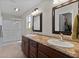 Bathroom with double sinks, decorative framed mirrors, and a walk-in shower with glass doors at 2008 Cipriano Pl, The Villages, FL 32159