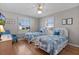 Bright guest bedroom featuring two twin beds, wood floors, ceiling fan, and natural light at 2008 Cipriano Pl, The Villages, FL 32159