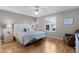 Bright bedroom with wood floors, ceiling fan, and large window with plantation shutters at 2008 Cipriano Pl, The Villages, FL 32159