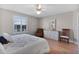 Charming bedroom showcasing hardwood floors, a ceiling fan, and abundant natural light through the windows at 2008 Cipriano Pl, The Villages, FL 32159