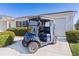 Blue golf cart parked on the driveway of a well-maintained home, showcasing outdoor living at 2008 Cipriano Pl, The Villages, FL 32159