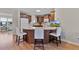 Breakfast bar with dark cabinetry and white stools in an open kitchen at 2008 Cipriano Pl, The Villages, FL 32159