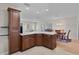 Spacious kitchen island with barstool seating, wooden cabinets, tile floor, and open to the dining area at 2008 Cipriano Pl, The Villages, FL 32159