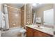 Neutral toned bathroom featuring a vanity with storage, marble countertop, and a tub and shower combination with tile surround at 21046 County Road 33, Groveland, FL 34736