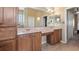 Bathroom with double sinks, custom cabinets, large mirrors, and a view into the hallway at 21046 County Road 33, Groveland, FL 34736