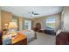 Relaxing bedroom featuring neutral walls, plush carpeting, a ceiling fan, and a window with a view at 21046 County Road 33, Groveland, FL 34736