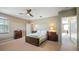 A cozy bedroom featuring neutral walls, carpeting, a ceiling fan, and a window with a view at 21046 County Road 33, Groveland, FL 34736