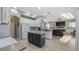 Modern kitchen featuring white cabinets, a contrasting island, stainless steel appliances, and tile flooring at 21046 County Road 33, Groveland, FL 34736