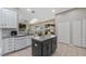 Bright, open kitchen featuring white cabinetry, a functional island, and views to the outdoor living space at 21046 County Road 33, Groveland, FL 34736