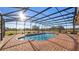 Relax in this screen-enclosed private pool overlooking a peaceful field with clear blue skies overhead at 21046 County Road 33, Groveland, FL 34736