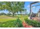 Backyard with manicured landscaping, green grass, and an attached screened-in patio with brick flooring at 2205 Stonebridge Way, Clermont, FL 34711