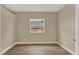 This is a cozy bedroom with a window, neutral tones, and hard wood floors at 2205 Stonebridge Way, Clermont, FL 34711