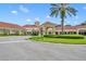 View of clubhouse with stucco exterior, terracotta roof, roundabout driveway, and manicured landscaping at 2205 Stonebridge Way, Clermont, FL 34711