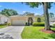 Charming one-story home with a well-manicured lawn, beautiful landscaping, and a two-car garage at 2205 Stonebridge Way, Clermont, FL 34711