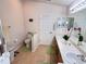 Bright bathroom with double sinks, toilet, and shower at 24614 Stillridge Ct, Leesburg, FL 34748