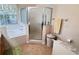 Bathroom featuring a shower with glass door and tub at 24614 Stillridge Ct, Leesburg, FL 34748