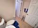 Cozy bathroom features white door, toilet, and tile flooring with a blue rug at 24614 Stillridge Ct, Leesburg, FL 34748