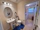 Bathroom showcasing vanity sink, toilet, mirror, and view into laundry room at 24614 Stillridge Ct, Leesburg, FL 34748