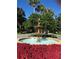 Beautiful tiered fountain in a landscaped circle with colorful flowers lining the road at 24614 Stillridge Ct, Leesburg, FL 34748