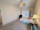 Bright main bedroom with plush carpet, ceiling fan, and sliding glass door at 24614 Stillridge Ct, Leesburg, FL 34748