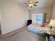 Carpeted main bedroom featuring a ceiling fan and sliding glass doors to the enclosed lanai at 24614 Stillridge Ct, Leesburg, FL 34748