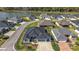 Aerial view of a blue single-Gathering home with a well-manicured lawn, a large lake, and tree-lined streets at 2919 Monument Way, The Villages, FL 32163