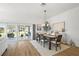 Bright dining room features a wooden table with seating for six, a modern chandelier, and sliding glass doors to the patio at 2919 Monument Way, The Villages, FL 32163