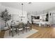 Open concept dining area with a view of the adjacent kitchen, featuring wood floors and a stylish chandelier at 2919 Monument Way, The Villages, FL 32163